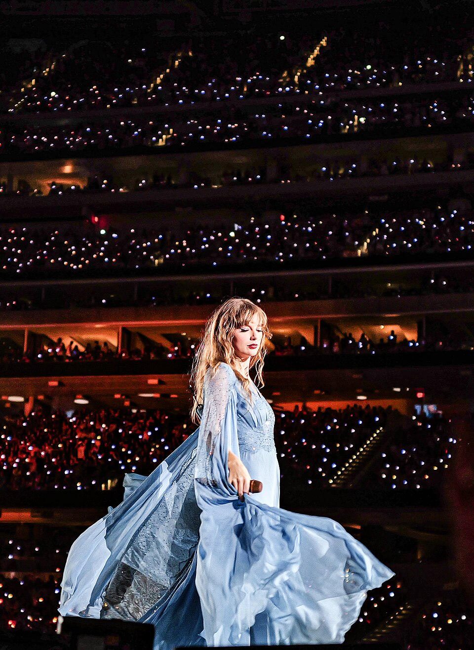 Taylor Swift wearing a blue dress on the Eras Tour stage in August 2023.